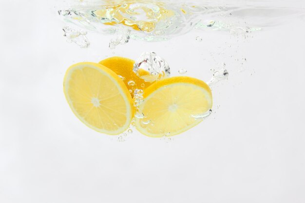 Sliced lemon falling in water