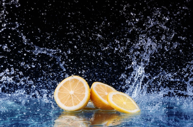 Sliced lemon in the water on black background