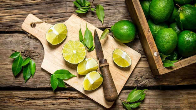 Sliced limes on a board with knife and box full .