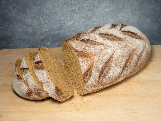 Sliced loaf of black bread on a kitchen board Bread on a black background Healthy food