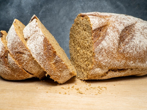 Sliced loaf of black bread on a kitchen board Bread on a black background Healthy food