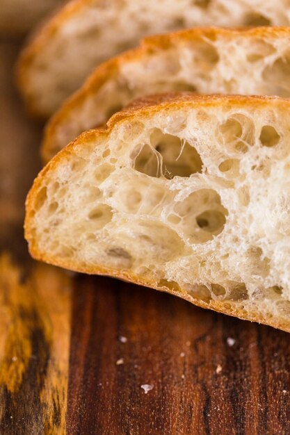 Sliced loaf of freshly baked ciabatta bread on gray table.