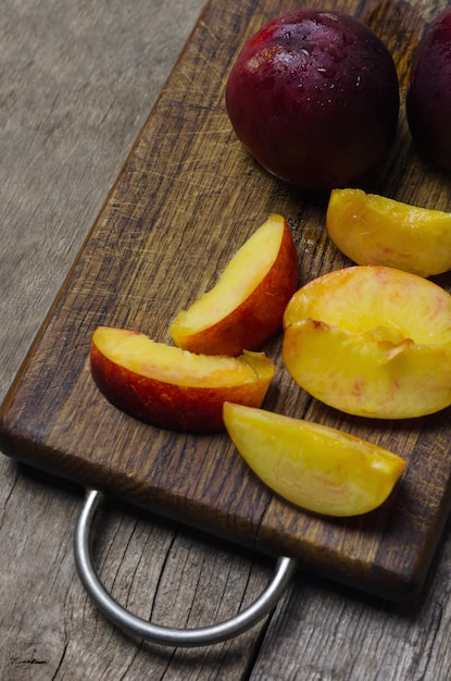 Sliced nectarine on wooden cutting board.