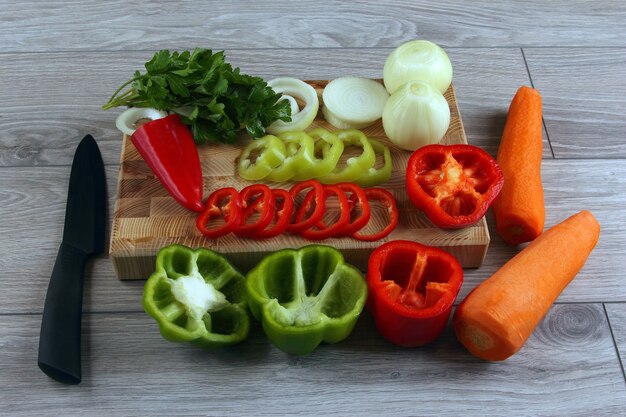 Sliced onion and pepper on a kitchen Board with parsley and carr