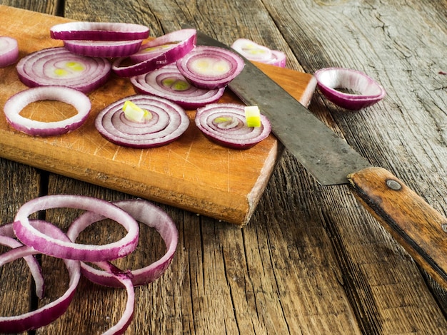 Cipolle tagliate con un coltello su un tavolo da taglio