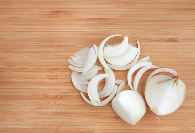 Sliced onions on wooden cutting board close up.