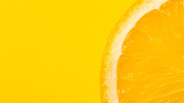 Sliced orange, yellow background, copy space. Fresh juicy fruit, source of vitamin C. Bright backdrop.