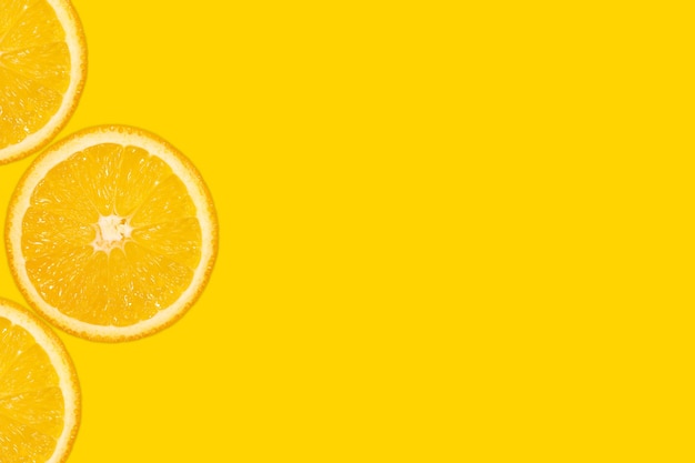 Photo sliced orange, yellow background, copy space. fresh juicy fruit, source of vitamin c. bright backdrop.