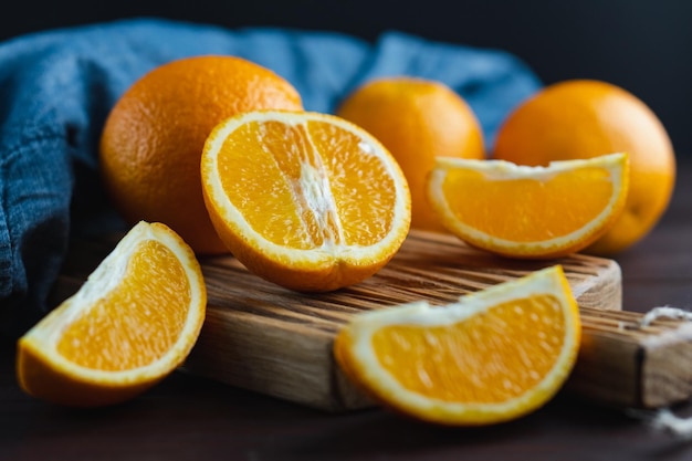 Sliced oranges fruit near denim textile on wooden board Orange juicy fruit citrus minimal concept