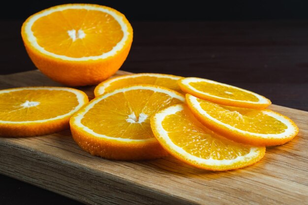 나무 커팅 보드에 얇게 썬 오렌지 과일 오렌지 즙이 많은 과일 감귤류 최소한의 개념 근접 촬영