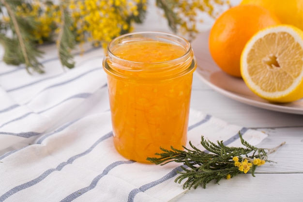 Sliced oranges and orange jam in a glass jar