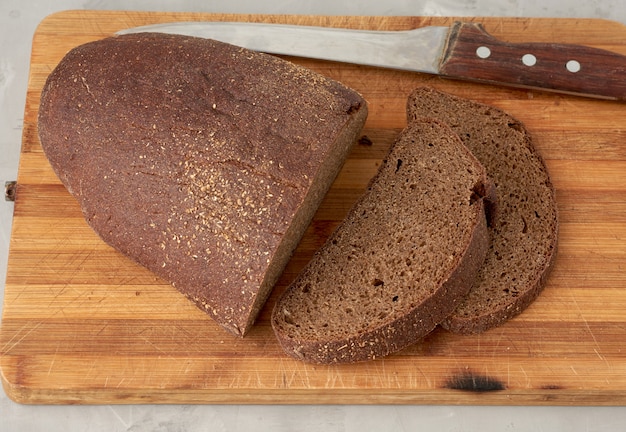 Sliced oval rye bread bread on a wooden board