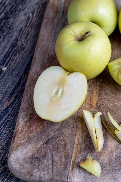 Photo sliced and peeled green apple on a wooden board