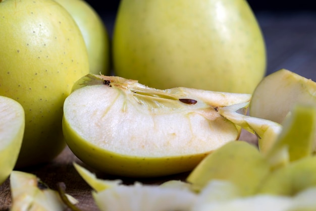 Photo sliced and peeled green apple on a wooden board