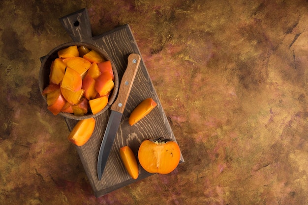 Photo sliced persimmons on wood cutting board