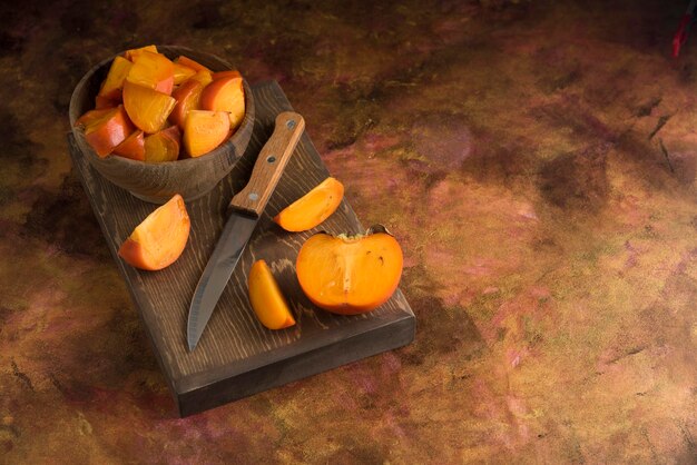 Sliced persimmons on wood cutting board