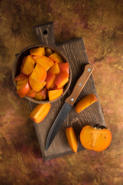 Sliced persimmons on wood cutting board