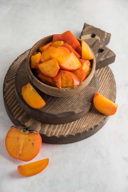 Sliced persimmons on wood cutting board