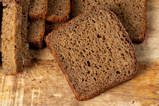 Sliced piece of black rye bread on a board