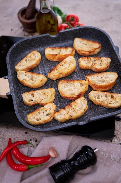 Sliced pieces of baguette on grill frying pan