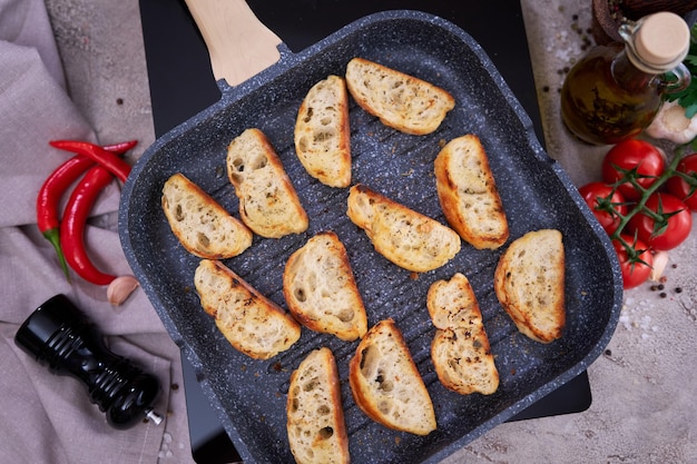 Sliced pieces of baguette on grill frying pan