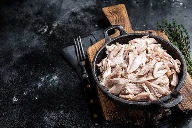 Sliced Pieces of chicken meat in a skillet pulled chicken Black background Top view Copy space