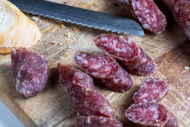 Sliced pieces of sausage from meat are lying on a cutting board pork meat with bacon is dried and withered the meat is ready for eating