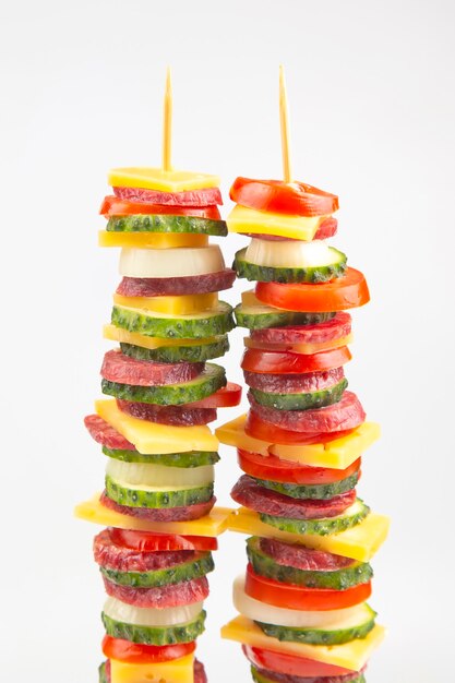 Sliced ââpieces of sausage, salami, cheese, cucumber and tomato. fast food. ingredients for pizza. calories and diet