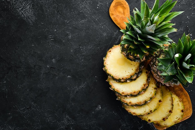 Sliced pineapple on a black background Tropical Fruits Top view Free copy space