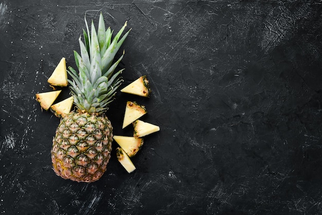 Sliced pineapple on a black background Tropical Fruits Top view Free copy space