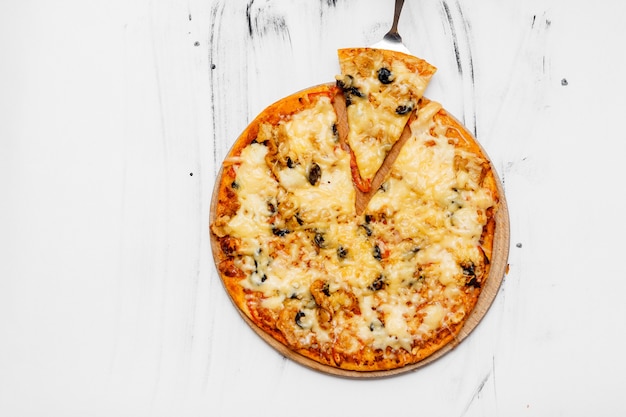 Sliced pizza with ingredients on white background. Top view, flat lay with copy space.