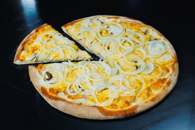 Foto pizza al taglio con cipolla e carne salsa di pomodoro mozzarella cipolla e bordo di pasta ripiena di crema di formaggio su sfondo nero