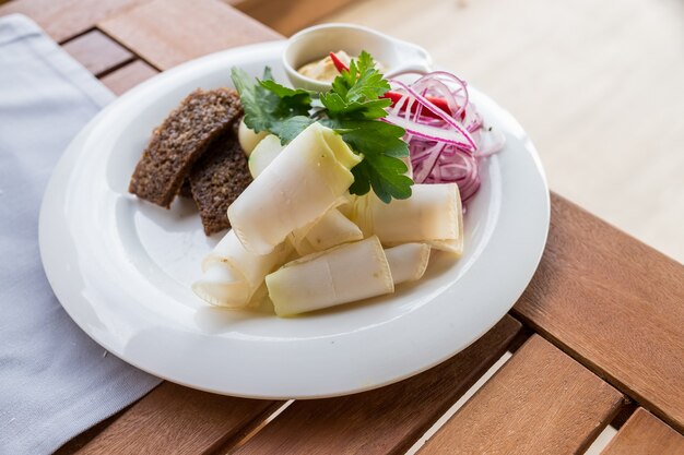 Sliced pork fat with onion and black bread on plate