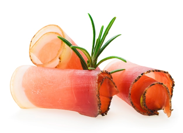 Sliced prosciutto with rosemary on white background