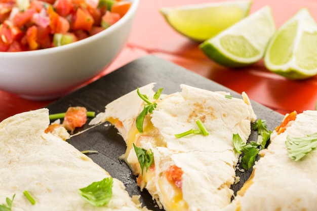 Sliced quesadilla filled with cheese, chicken and pico de gallo.