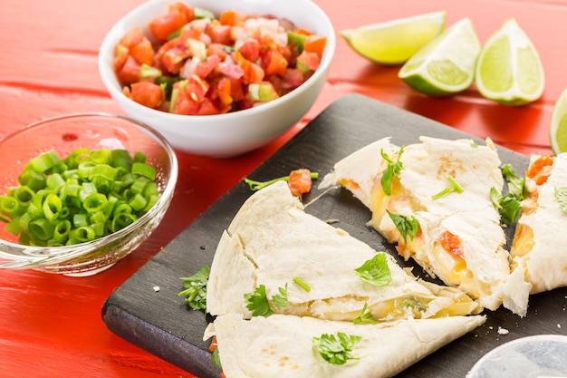 Sliced quesadilla filled with cheese, chicken and pico de gallo.