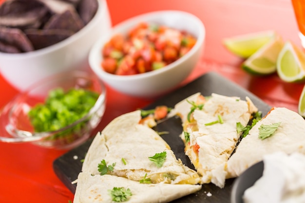 Sliced quesadilla filled with cheese, chicken and pico de gallo.