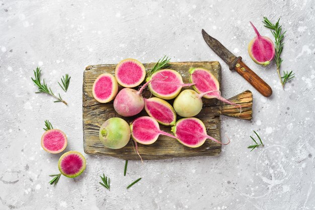 Sliced radish watermelon on the kitchen board Dietary useful vegetables On a gray stone background