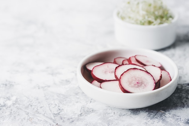 Sliced radish in a white bowl on the table