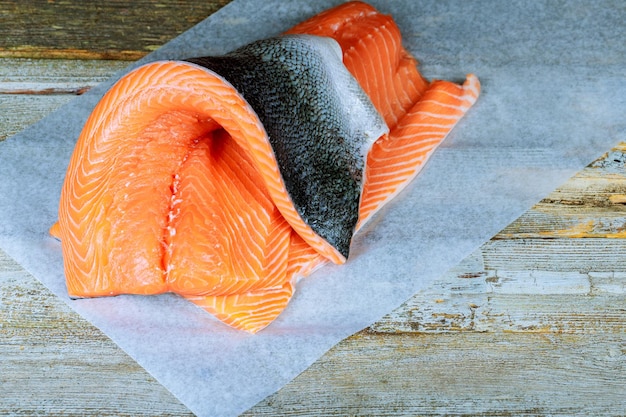 切り切られた生の煮たないサーモン 赤い魚はカウンターに横たわっている 魚と海産物のサーモンの皮の側面
