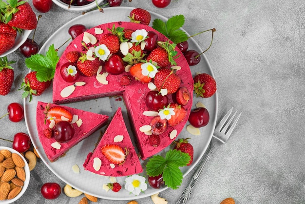 スライスされた生野菜のイチゴと桜のカシューケーキ新鮮なベリーナッツと花のベジ