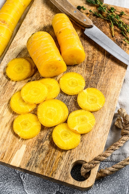 Sliced raw yellow organic carrots on a cutting board
