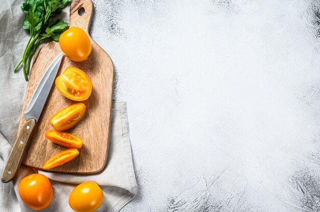 Sliced raw yellow tomato on a cutting Board