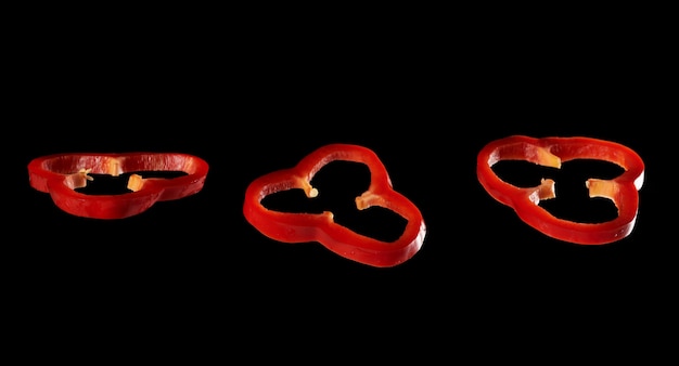 Sliced red bell pepper on black background