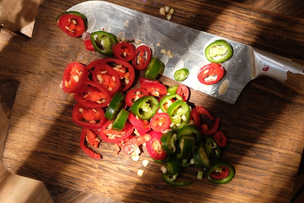 sliced red and green chilies on a teak wood cutting board. stainless steel blade. Capsicum annuum L