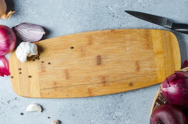sliced red onion and kitchen knife with wooden board