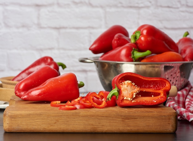 Sliced red pepper on a cutting wooden board, close up