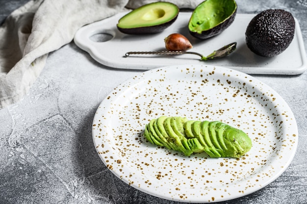 Sliced ripe avocado. Gray background. Top view