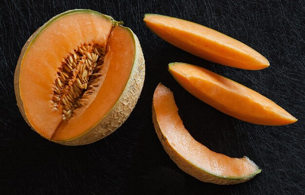 Sliced ripe melon on black background