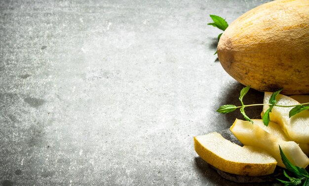 Melone maturo a fette con rami di menta.